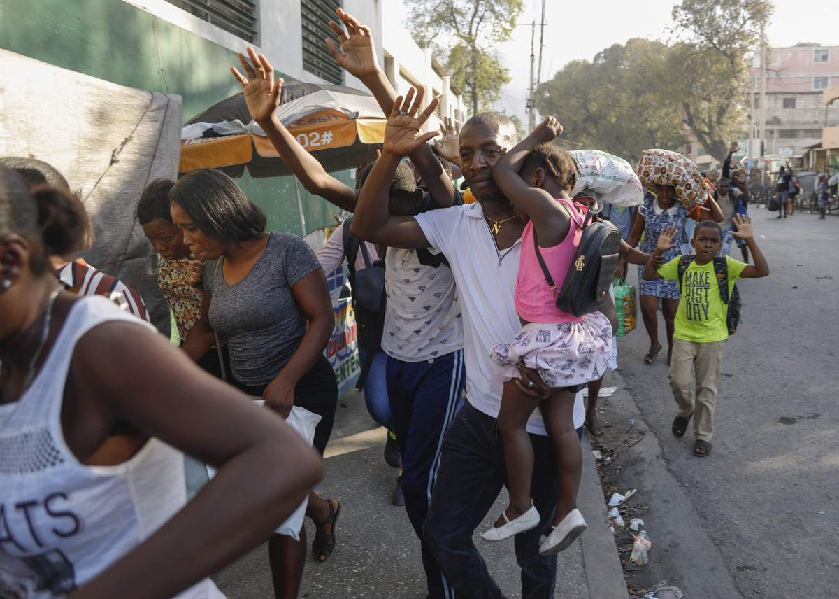 Njerëzit vrapojnë për t'u mbrojtur ndërsa bandat përleshen me policinë në Port-au-Prince, Haiti, më 29 shkurt