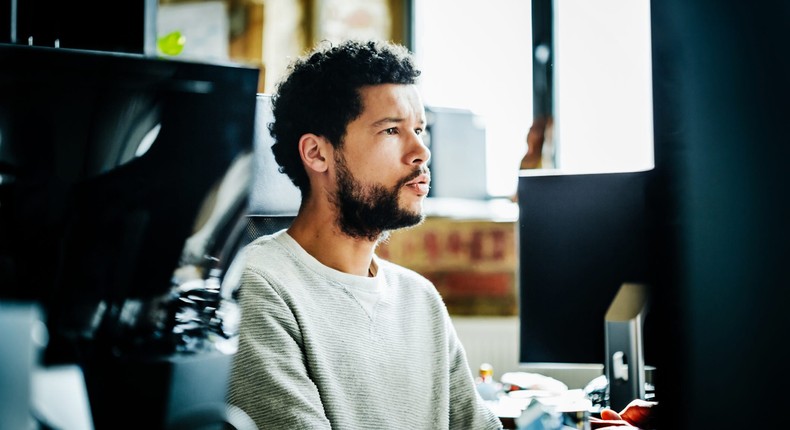 Man adding footnotes to presentation on office computer