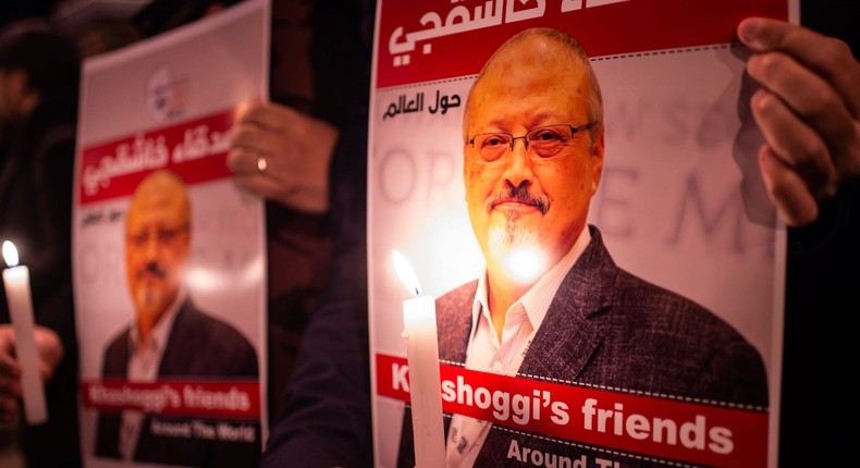 People hold posters picturing Saudi journalist Jamal Khashoggi and lightened candles during a gathering outside the Saudi Arabia consulate in Istanbul, on October 25, 2018.
