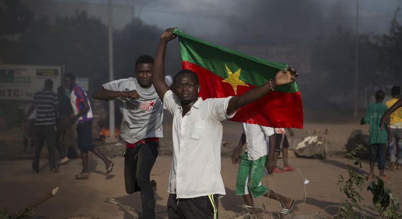 An anti-coup protester holds a Burkinabe flag in Ouagadougou, Burkina Faso, September 18, 2015. Leaders of a coup in Burkina Faso said on Friday they had freed the president and reopened borders, in an apparent olive branch to mediators and protesters who rallied in the capital and other cities against the putsch. REUTERS/Joe Penney