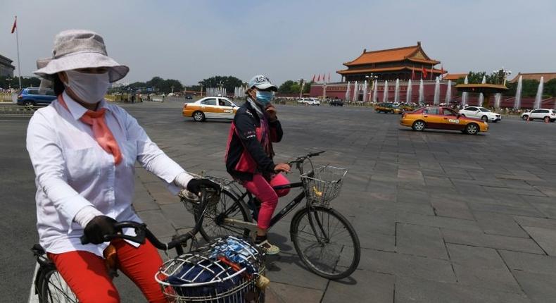 Cyclists ride past Tiananmen Gate on the eve of the 28th anniversary of the June 4, 1989 crackdown on pro-democracy protests in Beijing