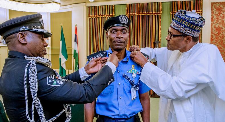 Mohammad Adamu (middle) decorated by Idris Ibrahim (left) and President Muhammadu Buhari (right) as the new Inspector-General of Police [Twitter/@NGRPresident]