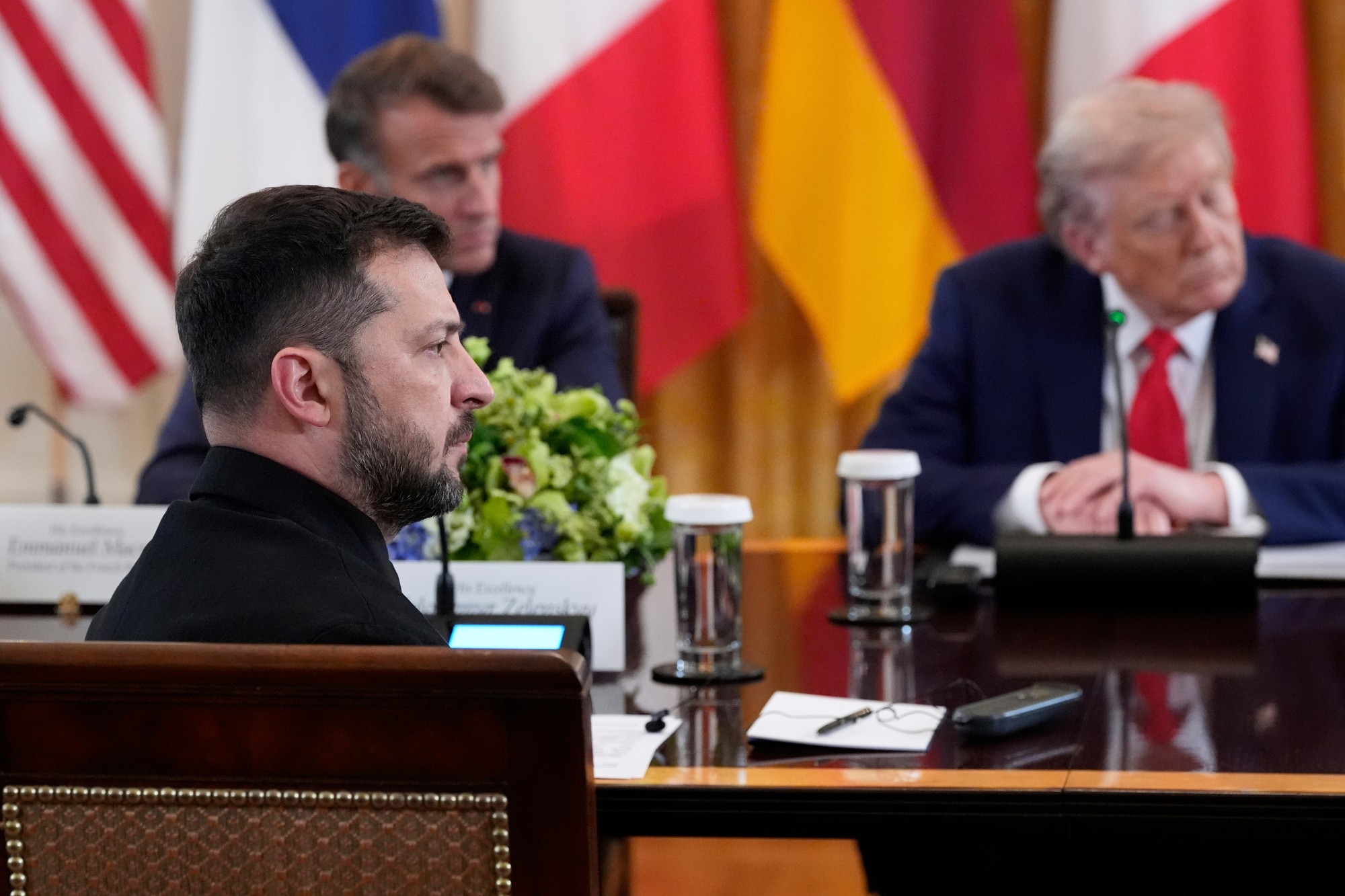 Ukrajinský prezident Volodymyr Zelenskyj (v popredí), francúzsky prezident Emmanuel Macron (v pozadí vľavo) a prezident Donald Trump.