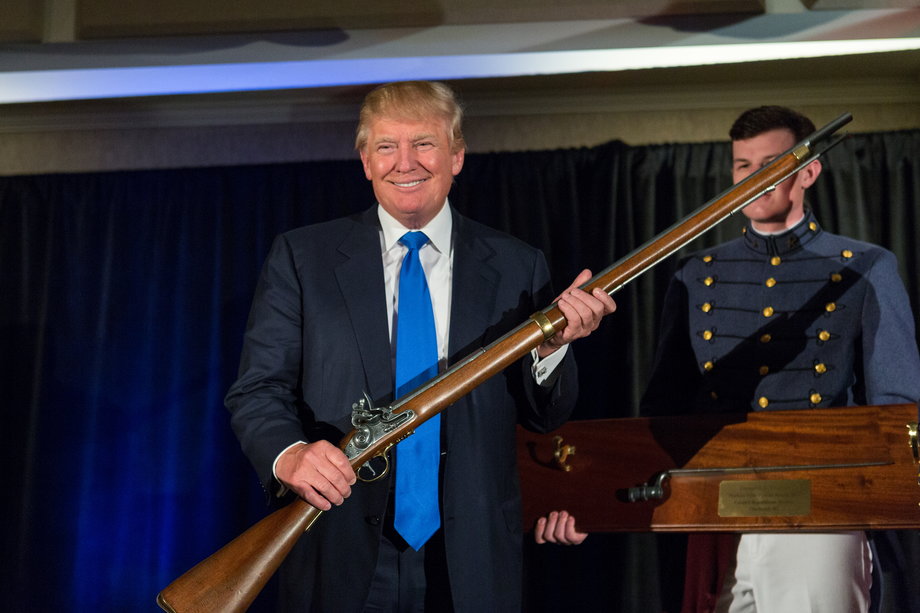 Donald Trump holds up a replica flintlock rifle.