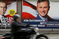 A motorcyclist passes presidential election campaign posters of Van der Bellen and Hofer in Vienna