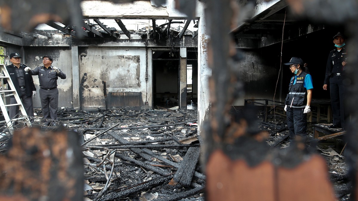 Forensic experts inspect a burnt building at the Pitakkiat Wittaya School in the northern province of Chiang Rai