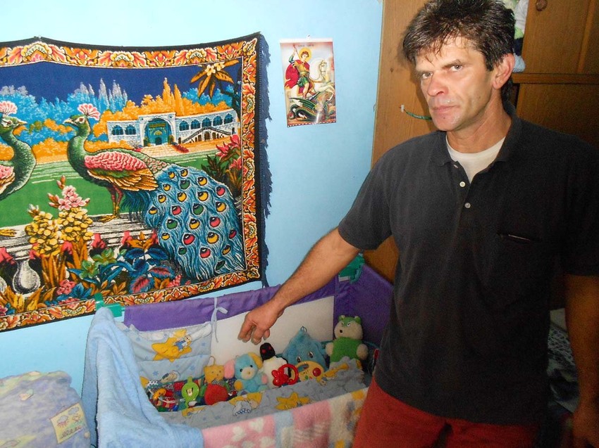 Otac pored kolevke u kojoj je beba spavala