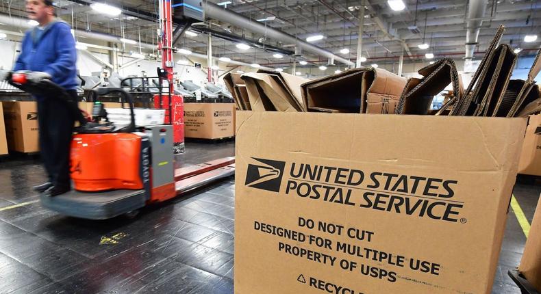 A US Postal Service employee moves past boxes during the 2019 Christmas season.