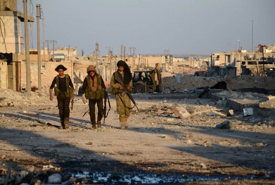 Turkish-backed Syrian rebels patrol through the town of al-Bab shortly after they captured it from ISIS.