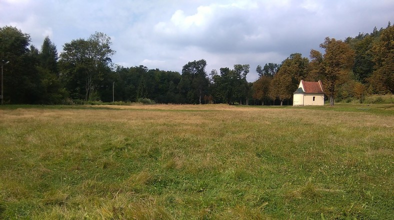 Widok z "linii bramkowej" na dawne boisko. W oddali zabytkowa kapliczka