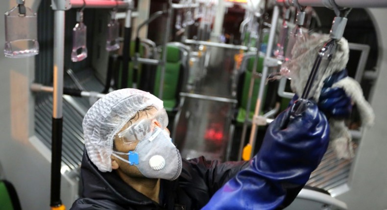 A Tehran municipality worker cleans a bus to avoid the spread of COVID-19