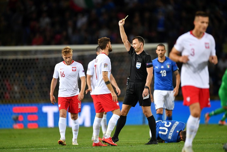 Zawodnik reprezentacji Polski Mateusz Klich (C) otrzymuje żółtą kartkę