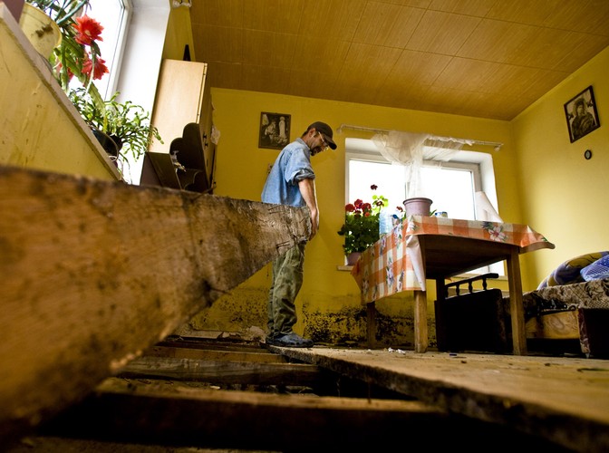 Mężczyzna sprząta swój zniszczony przez powódź dom we wsi Wilków (woj. lubelskie)