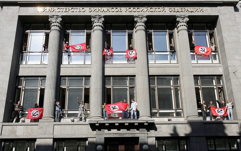Miembros del Partido Nacional Bolchevique protestan frente al edificio del Ministerio de Finanzas ruso en Moscú, colgando banderas de su grupo en sus ventanas.