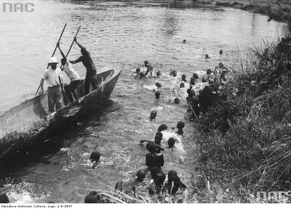 Kazimierz Nowak w misji katolickiej (płynie na czółnie). W wodzie przy brzegu pływają dzieci - rok 1935, Kongo Francuskie