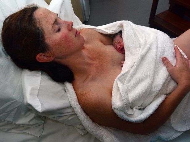 Kobieta odpoczywa po porodzie z noworodkiem