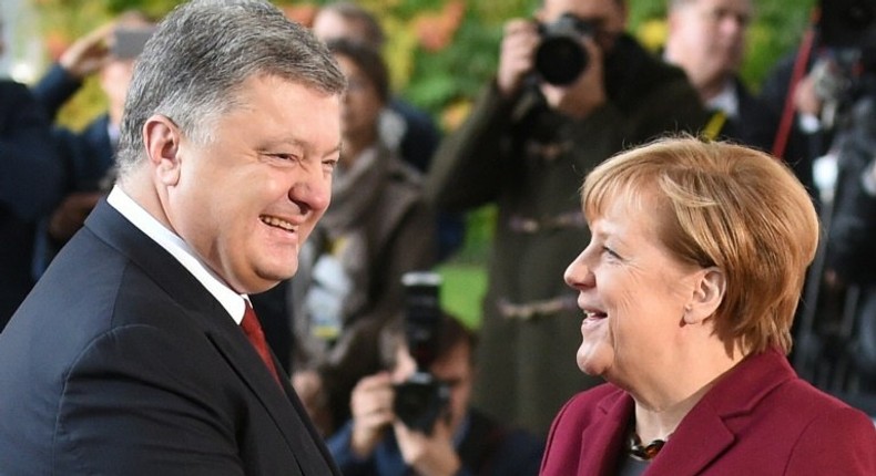 German Chancellor Angela Merkel (R) welcomes Ukrainian President Petro Poroshenko upon arrival at the chancellery on October 19, 2016 in Berlin