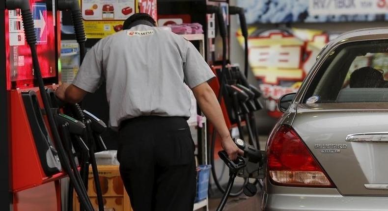 A gas station worker fuels a vehicle in Tokyo August 26, 2015. REUTERS/Toru Hanai