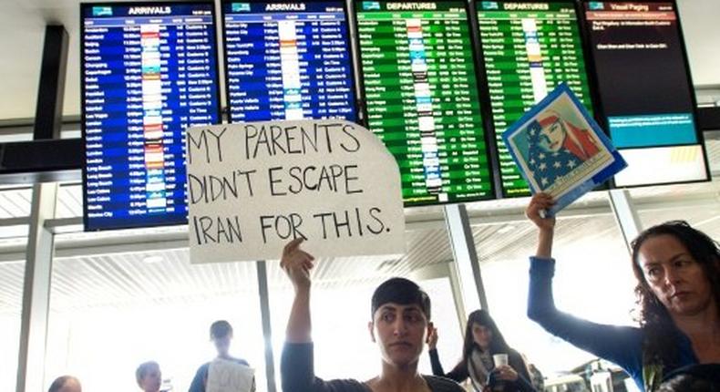 Protesters hold signs up during a protest at San Francisco International Airport in California on January 29, 2017