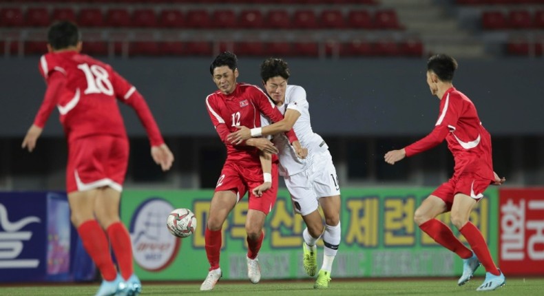 South Korea's Hwang Ui-jo and North Korea's Ri Yong Jik fight for the ball during the World Cup 2022 Qualifying match in Pyongyang