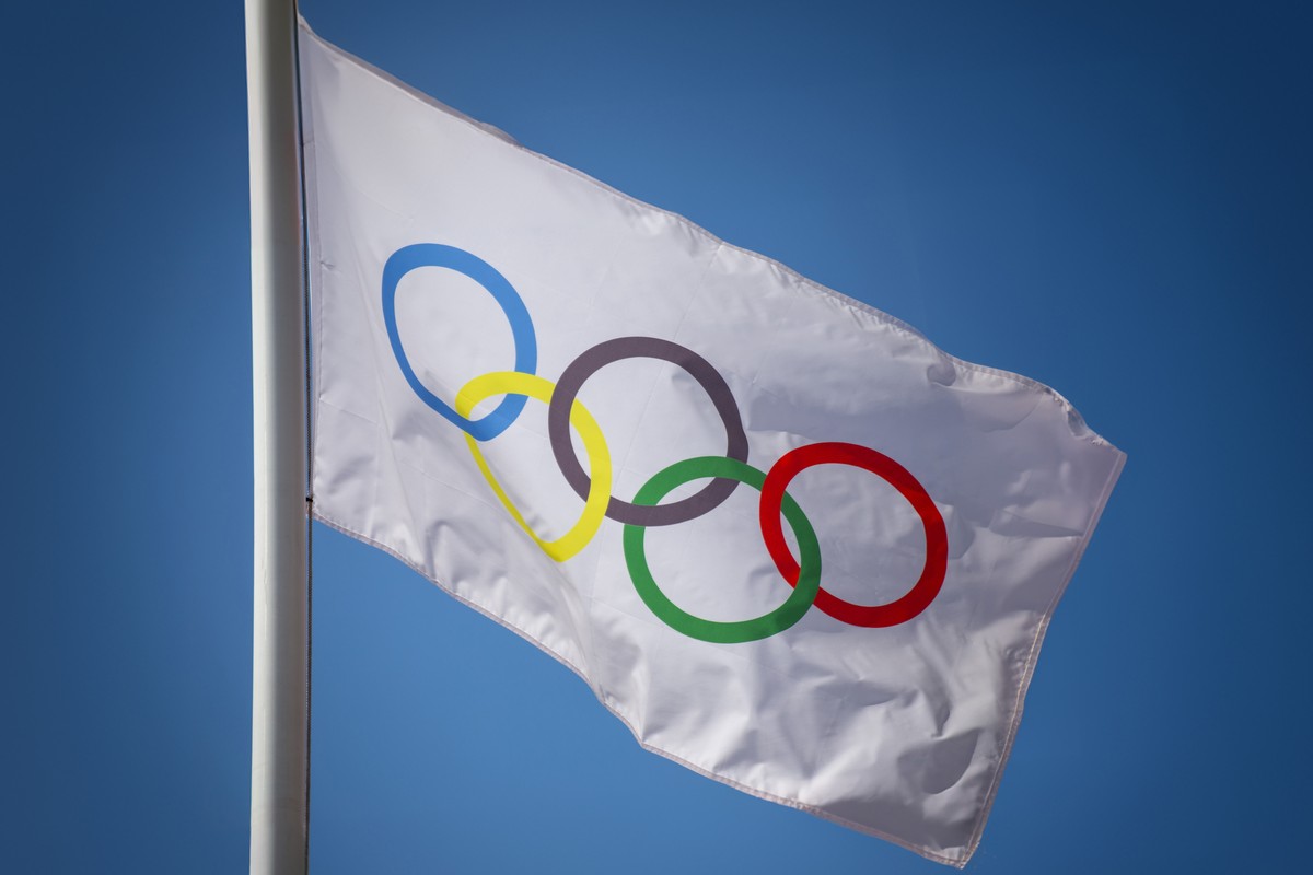 Flaga olimpijska powiewa na wietrze na tle niebieskiego nieba