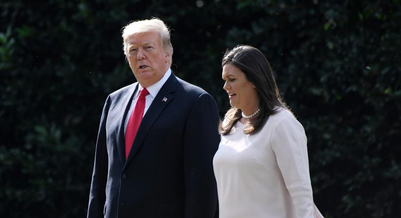 Then-President Donald Trump walks with White House Press Secretary Sarah Huckabee Sanders as they leave the White House on October 9, 2018.