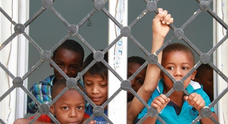 Displaced Libyan children who fled the eastern Libyan cities of Abu Grein and Sirte look out of window at a school where they are taking shelter in Bani Walid, in May 2016 