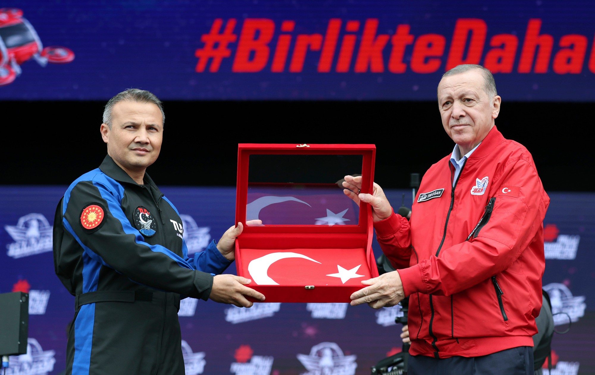 Erdogan drží tureckú vlajku s pilotom tureckých vzdušných síl Alperom Gezeravcim na vojenskom veľtrhu Teknofest v Istanbule.