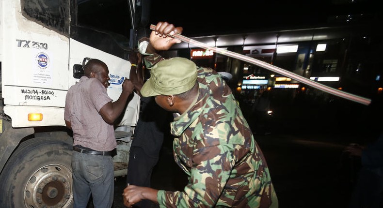 Police canning a driver caught outside during curfew hours