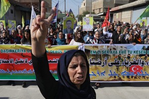 Kurdish and Arab protesters chant slogans against Turkish President Tayip Erdogan as they walk during a march to the United Nations Headquarters in the town of Qamishli