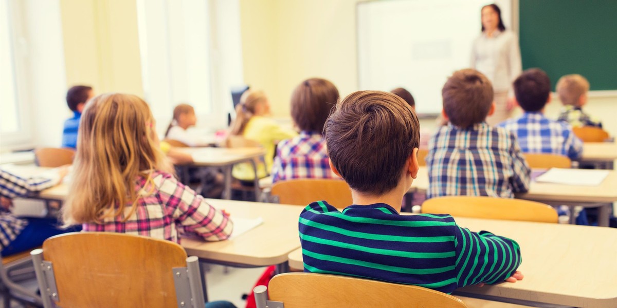 group of school kids and teacher in classroom