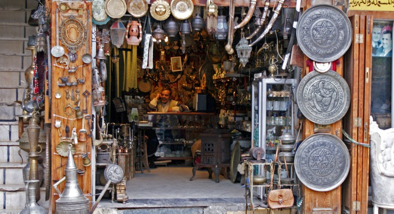 A vendor sits inside an antique shop in al-Jdeideh neighborhood, in the Old City of Aleppo, in 2009.