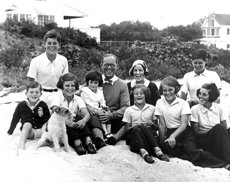 Rodzina Kennedych w Hyannis Port (Kennedy Compound), stan Massachusetts (4 września 1931 r.). Siedzą od lewej: Bobby, John, Eunice, Jean (na kolanach) Joe Sr., Rose (za) Pat, Kick, Joe Jr. (za) Rosemary. Teda nie było jeszcze na świecie. Pies na pierwszym planie to „Buddy”