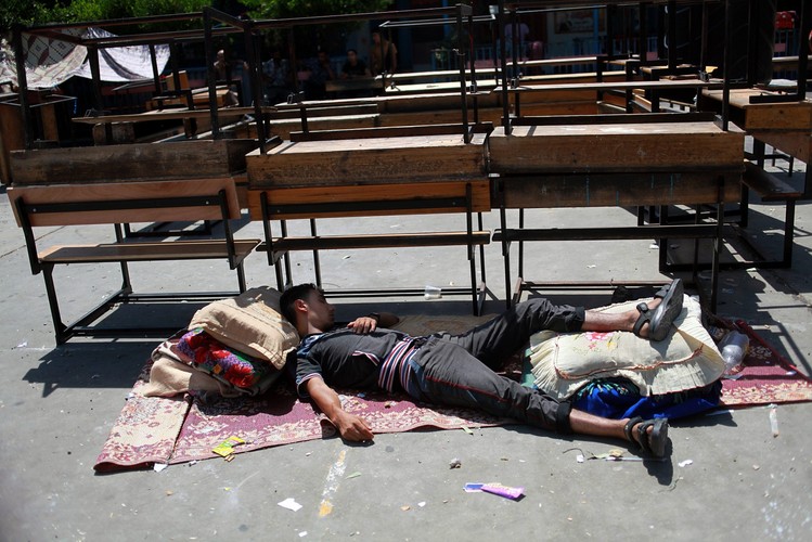 Palestyńczyk śpi pod gołym niebem po ataku na szkołę w Strefie Gazy