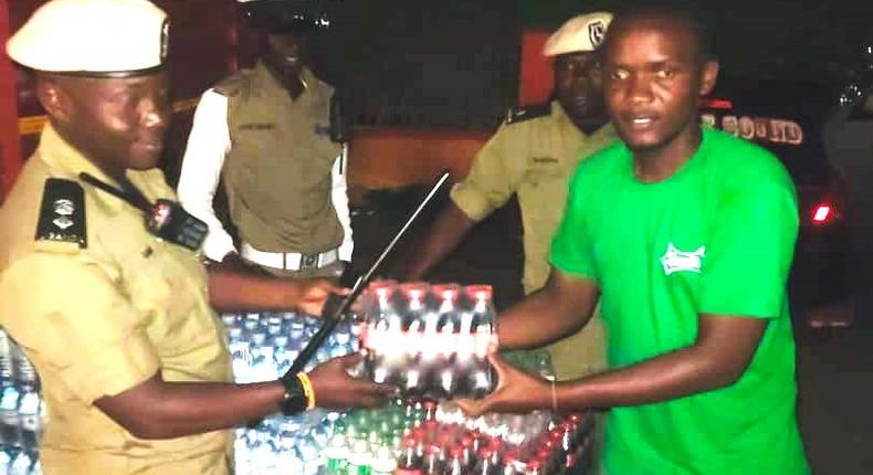 SSP Rogers Nsereko Kauma, the Kampala Metropolitan Traffic Police Commander recieving the refreshementfrom CCBU's Kirunda Magoola