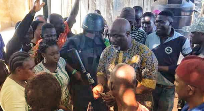 Dino Melaye surrounded by his supporters at the shop of a bean cake seller. (Micheal Odoh/Twitter)