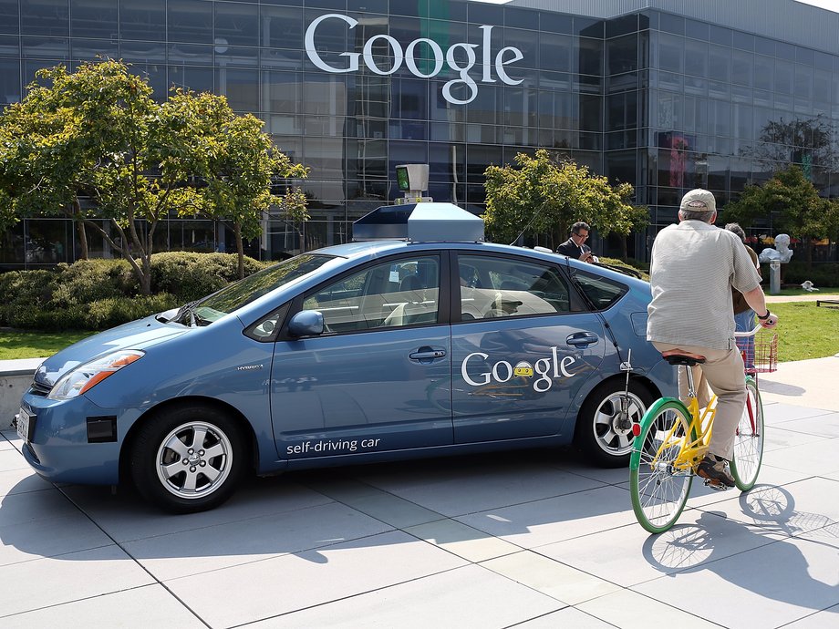 A cyclist passes an early Google self-driving car in 2012