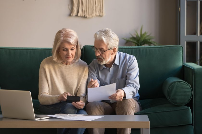 Serious mature couple calculating bills, checking domestic finances