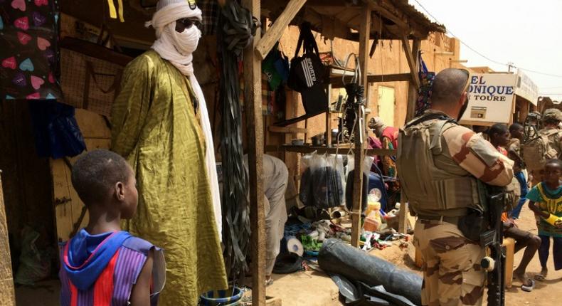 Far from home: A member of France's Barkhane force patrols the market in Menaka, northeastern Mali