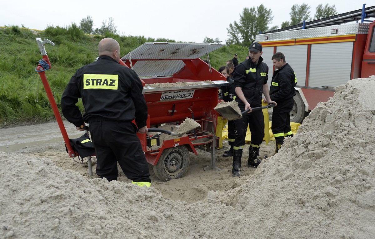 Strażacy napełniają piaskiem worki, które zostaną ułożone na koronie wału przeciwpowodziowego w delcie Wisły i Sanu we Wrzawach