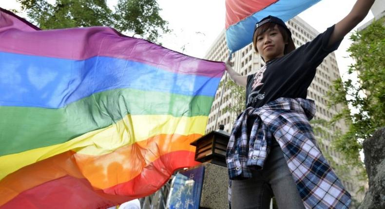 A supporter of same-sec marriage holds a rainbow flag outside the Parliament in Taipei on November 17, 2016