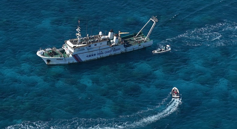 This photo taken on February 15, 2024, shows an aerial view of a China Coast Guard vessel and China Coast Guard personnel on a rubber boat over Scarborough Shoal in the disputed South China Sea.JAM STA ROSA / AFP