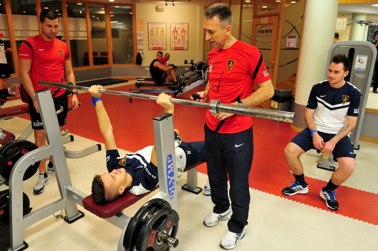 Piłkarz Pogoni Michał Janota podczas ćwiczeń na siłowni