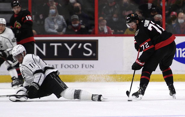 Hokeista Los Angeles Kings Anze Kopitar (L) blokuje strzał Thomasa Chabota (P) z Ottawy Senators