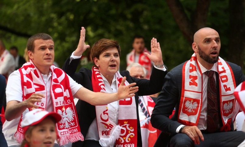 W ogrodach KPRM wspólnie z premier Szydło mecz oglądali m.in.: minister sportu Witold Bańka, minister pracy Elżbieta Rafalska, wicepremier i minister nauki Jarosław Gowin, szef resortu skarbu Dawid Jackiewicz, minister zdrowia Konstanty Radziwiłł, politycy PiS z rodzinami, a także były trener polskiej reprezentacji Andrzej Strejlau, piłkarz Sebastian Mila oraz koszykarz NBA Marcin Gortat, który w przerwie meczu wręczył pani premier swoją koszulkę meczową. Polskim piłkarzom kibicowały też dzieci z dwóch warszawskich podstawówek. Przed meczem goście typowali wynik. 2:0 dla Polski obstawiła premier Szydło. Wspaniały mecz, niełatwy, ale chapeau bas dla obydwu zespołów, to rzeczywiście fantastyczne po prostu. Najważniejsze jest zwycięstwo - podkreśliła. Na pytanie, kto według niej był zawodnikiem meczu oceniła, że Robert Lewandowski. Premier pytana była też o przewidywania, jeśli chodzi o mecz Polaków w kolejnej fazie rozgrywek Mistrzostw Europy w Piłce Nożnej 2016; w 1/8 finału podopieczni Adama Nawałki zmierzą się ze Szwajcarią. - Żeby nie zapeszyć, ale damy radę - odparła.