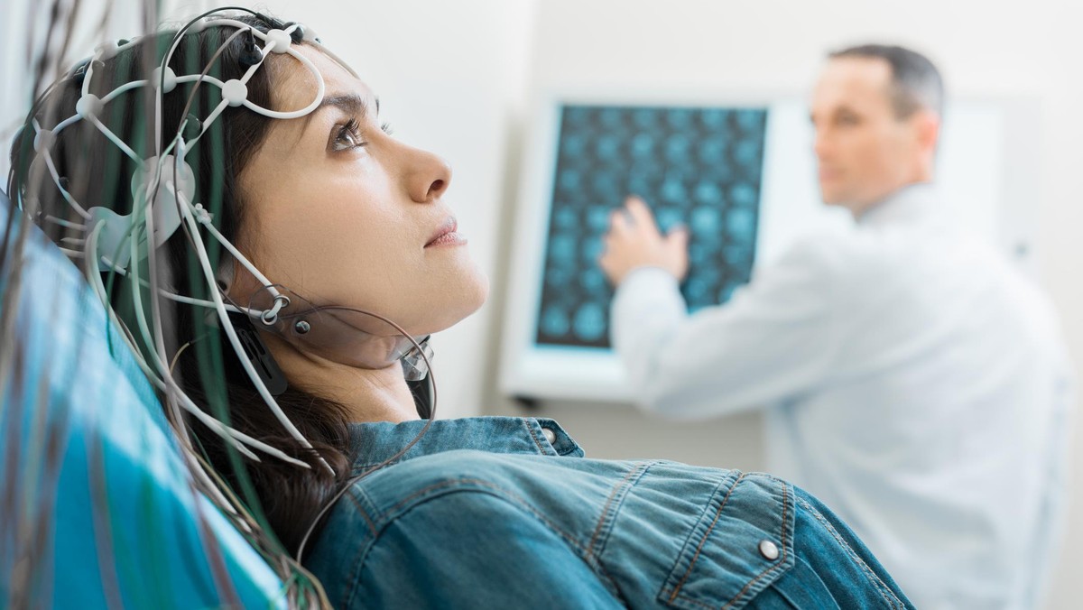 Charming young woman undergoing electroencephalography