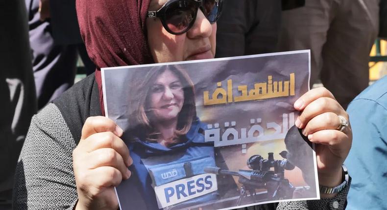 Une femme portant une affiche avec le visage de la journaliste assassinée — HAZEM BADER - AFP