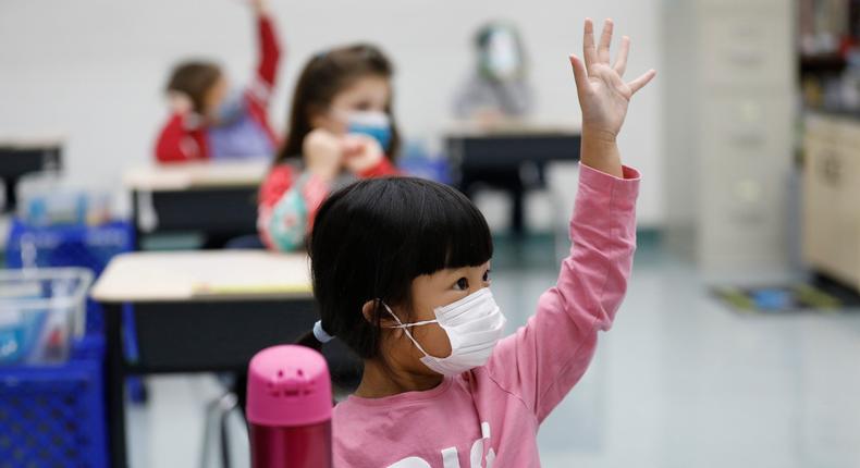 Kindergarten students raise their hands at Lupine Hill Elementary School in Calabasas, California, on November 9, 2020.