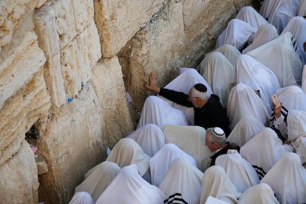 Jewish worshippers wrapped in prayer shawls participate in the priestly blessing prayer on the holid