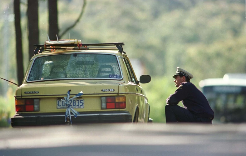 Policjant stoi w pobliżu porzuconego pojazdu Martina Bryanta po masakrze w Port Arthur, 1996 r.